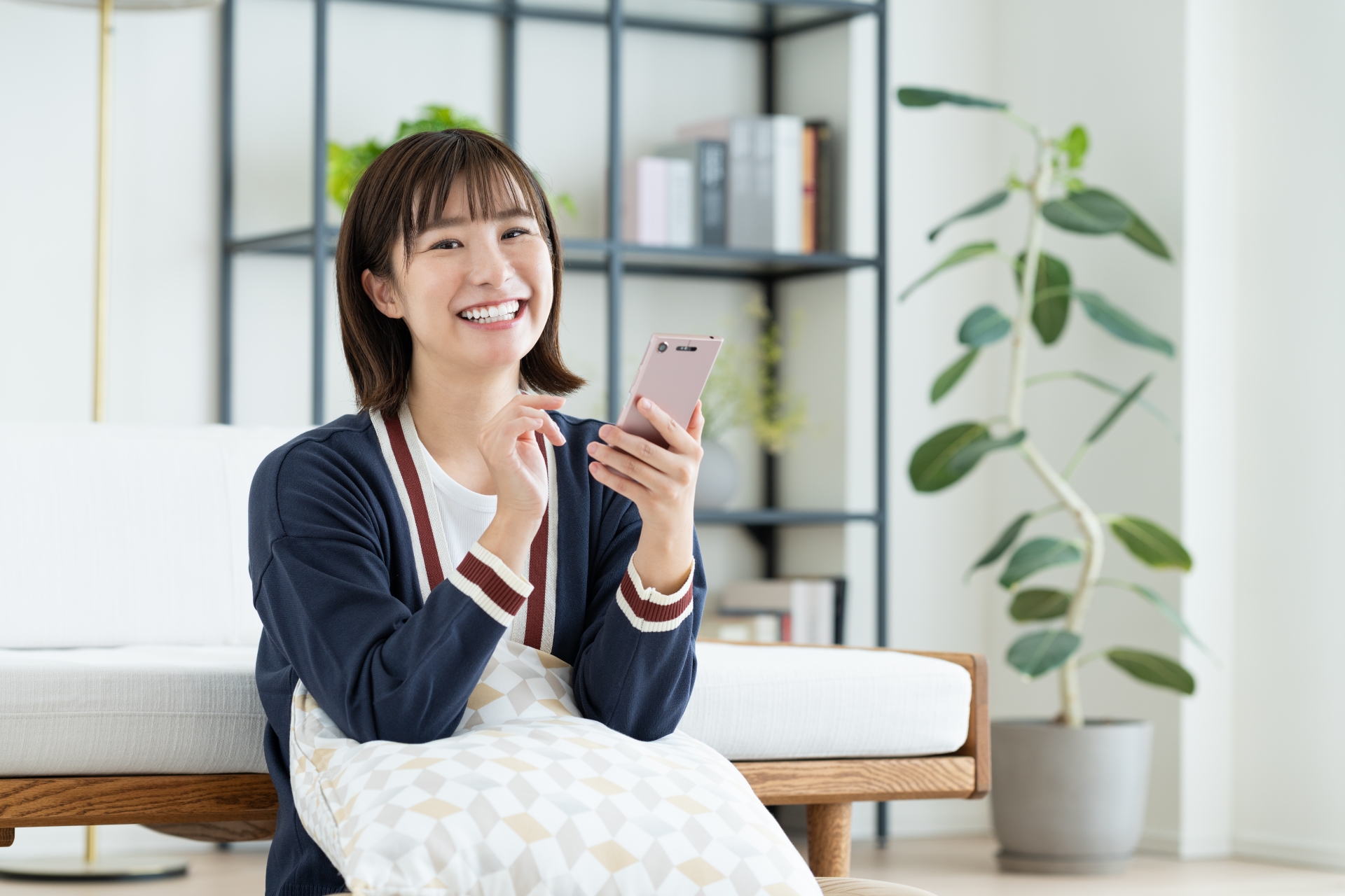 リビングでスマホを持つ女性